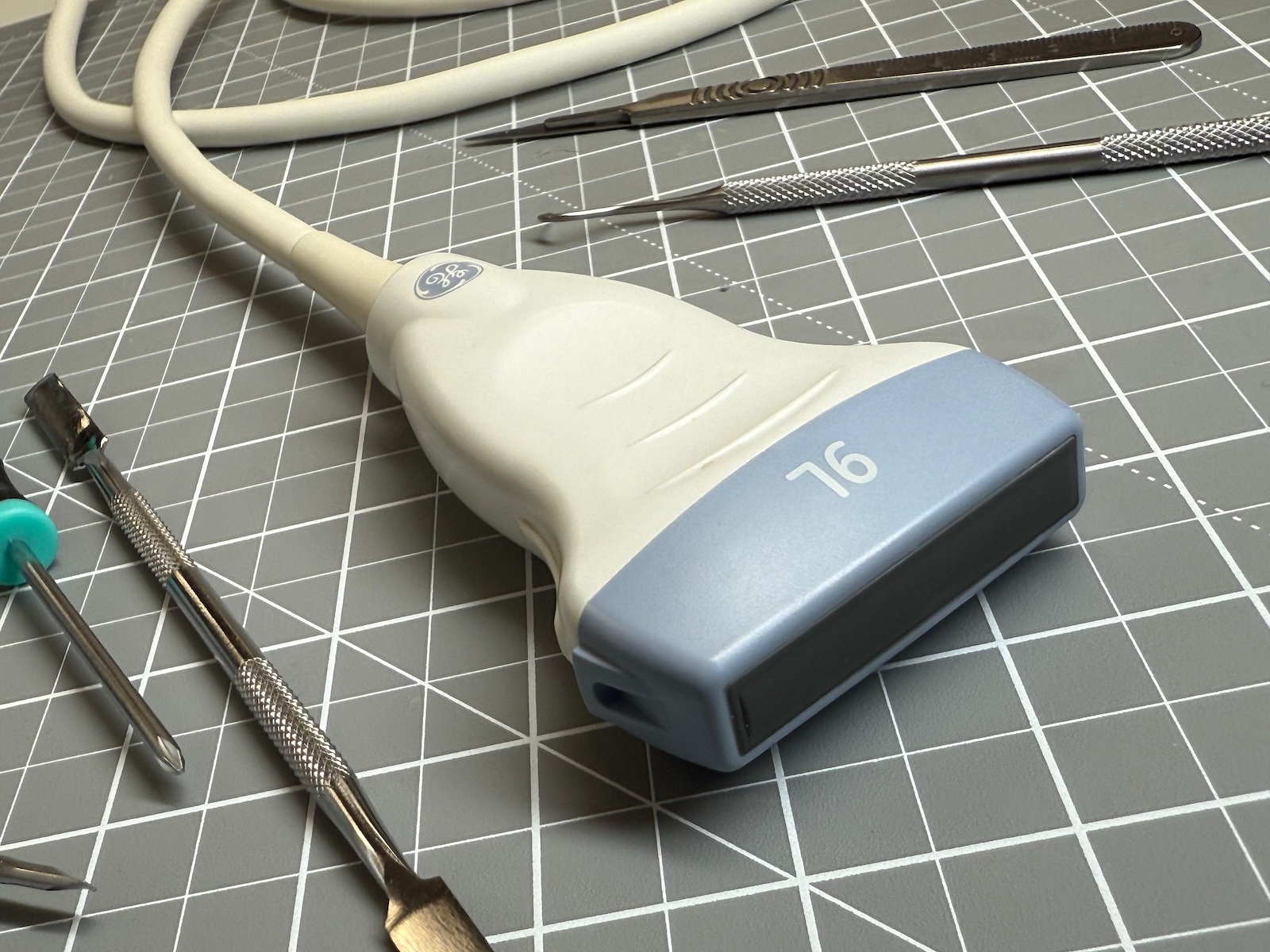 professional ultrasound repairs. Closeup of a machine head on a mat ready for repair, along with some tools.